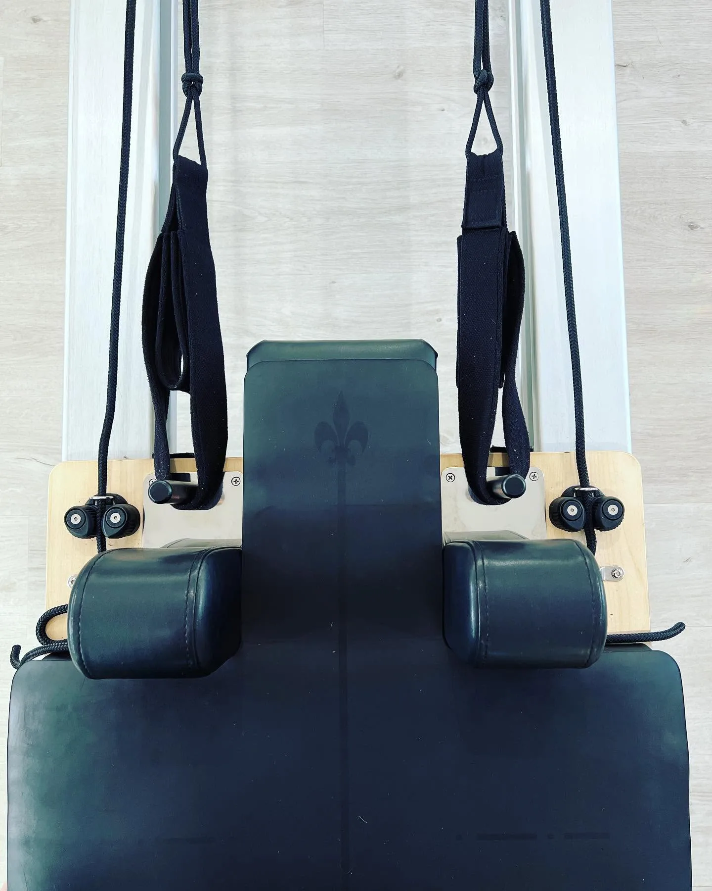 Overhead detail of a reformer's shoulder rests, straps and foot-bar